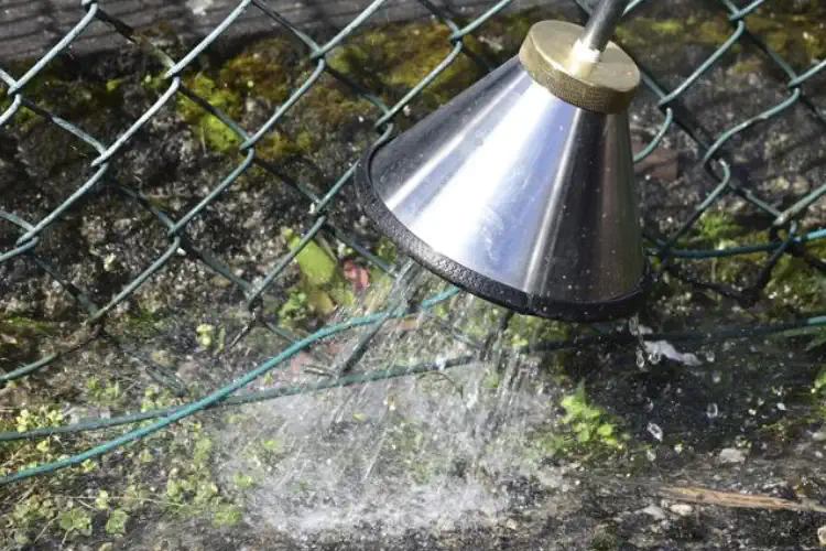 Close up of the hot water nozzle as it blasts weeds with hot water